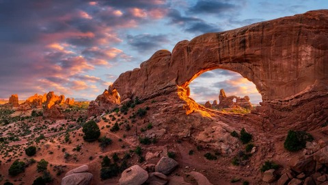 Avondlicht boven Noord-venster met torentje boog in de verte, Arches National Park Utah